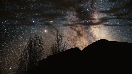 Timelapse Storm over Monument Valley rock reveals. Star Trails Galaxy Spins Behind the Rock. Milky...
