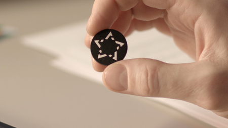 Close up view of a button from a shirt with pattern in the shape of a star
