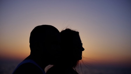 Close-up on young couple silhouette at the sunset in a park. Stock. Romantic young couple silhouetteの写真素材