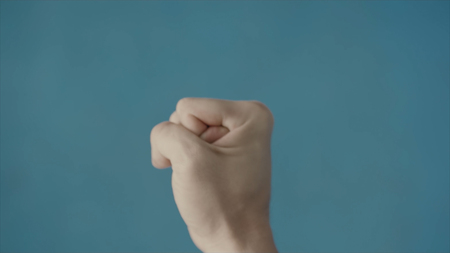 Top view of karate fighter making hand gesture close-up. Stock. A man gestures combat fighter.