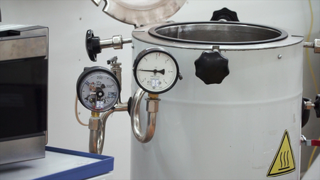 Pressure compound gauge psi meter in pipe and valves of water system industrial focus left closeup....