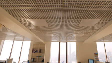 View of business office with one employee sitting at work alone. View of large open plan office with hard worker. Concept of office workの写真素材