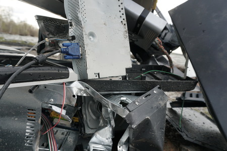 Broken computer parts, monitors and printers in front of nature landscape with a river background....
