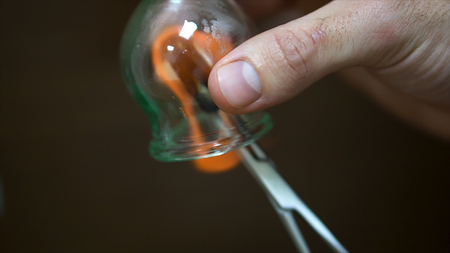 Close up for cupping therapist hand heating up a cupping glass with a flame, isolated on black...