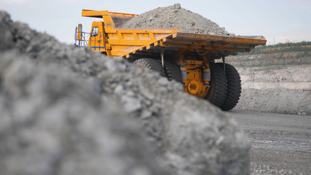 Truck driving career on road. Dump truck carries ore mined in open pit. Heavy large transport in...