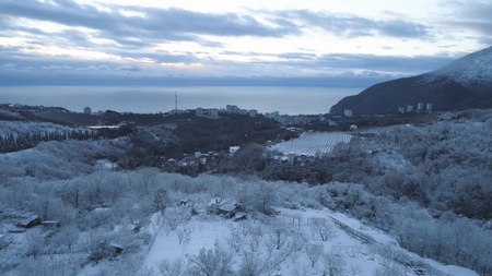 Top view of the city near the sea in winter. Shot. Snowy expanses in the mountainous area near the cityの写真素材