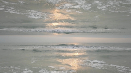 Beautiful seascape with horizon mirror effect with waves crashing on the shore. Endless waves with...
