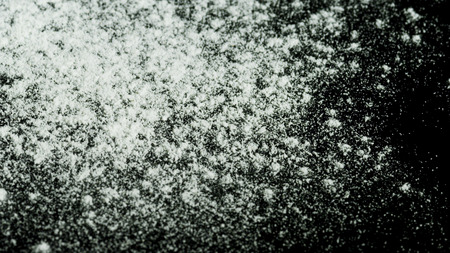 White powder falling down isolated on black background. Stock footage. White dry inks dropping on dark surface.の写真素材