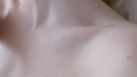 Female clavicles and neck. Action. Female clavicle. Perfect skin of a young woman close-up