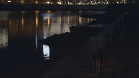 Empty asphalt sidewalk near the river, city at night. Stock footage. Beautiful night city landscape with embankment, benches near the river.の写真素材