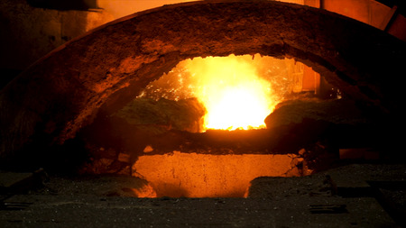 Close up for blast furnace and hot molten steel being poured into the chute, heavy industry concept....