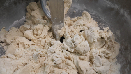 Close up for making food process, mixing dough at the factory. Stock footage. Kneading machine at the bakery, pastry preparation equipment.の写真素材