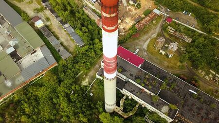 Top view of industrial pipe with old production buildings. Action. Old suburban industrial area with factories and plant with pipe.の写真素材