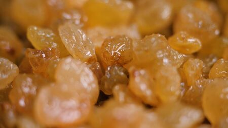 Close-up of lots of yellow raisins. Stock footage. Background of fresh yellow raisins for making sweet pastries. Sweet dried fruitsの写真素材
