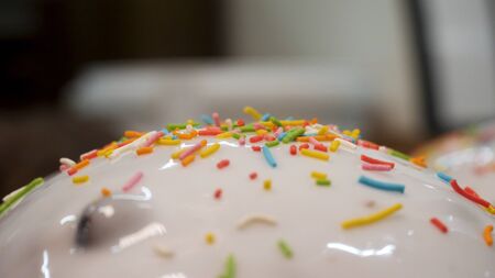 Close up for home made easter cake with white glaze and colorful sweet confetti, orthodox holiday and food concept. Stock footage. Tasty cakes freshly baked.の写真素材
