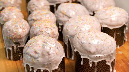 Close up for traditional Easter cakes in craft paper standing on wooden table, food and cooking...