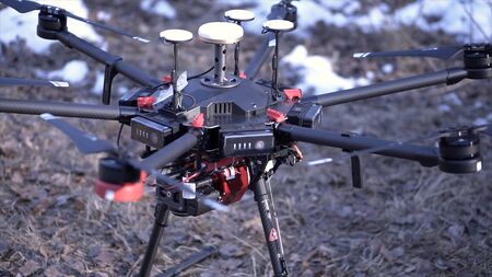 Close-up of men prepared quadcopter for flight. Clip. Two men admire latest version of quadcopter with powerful motors and professional camera for photography from airの写真素材