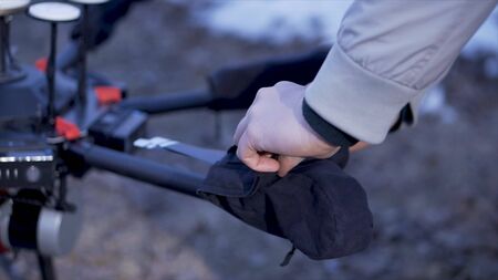 Close-up of men prepared quadcopter for flight. Clip. Two men admire latest version of quadcopter...