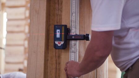 Working measures the height of the laser device. Clip. A young construction engineer makes room measurements with a laser rouletteの写真素材
