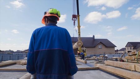 Construction engineer supervising work at building site. Clip. Builder in a helmet on the...