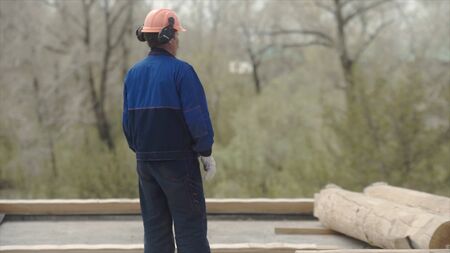 Process of building a private house. Clip. Builder in a helmet and uniform on construction of the...