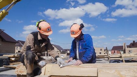 Construction workers in construction site safety uniform. Clip. Two builders in a helmet on the construction siteの写真素材