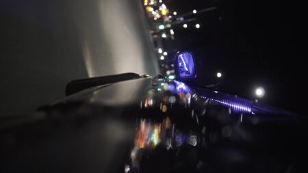 Night city from the car back view. Footage. Car rear view mirror in the city at night