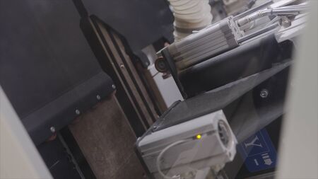 Modern machine making cuts on wooden boards. Action. Professional equipment at woodworking...