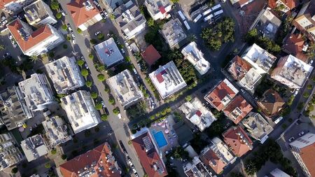 Top view of roofs and streets of city in summer. Clip. Beautiful southern city with orange roofs,...