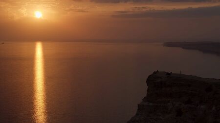 Aerial view of a golden sunset sky background with evening clouds over the sea. Shot. Stunning sky clouds in the sunset with a bright sun path on the sea surface.の写真素材