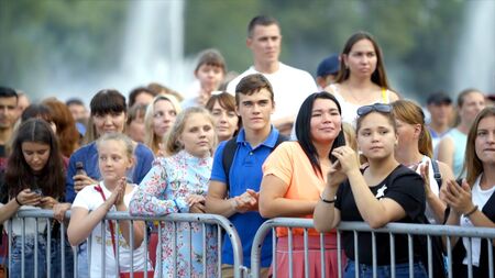 Yekaterinburg, Russia-August, 2019: Crowd of people applauds behind fence at festival. Action. People applaud at outdoor show or concert on summer dayのeditorial素材
