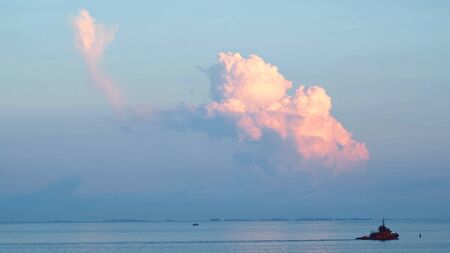 View of a passing ship near the sea shore. Shot. Beautiful view of the sea and clouds