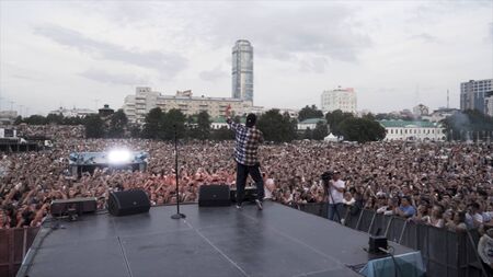Russia - Yekaterinburg, 08.15.2019: A huge crowd of fans watching russian rapper performing live on the stage. Action. Young artist in front of his fans.のeditorial素材