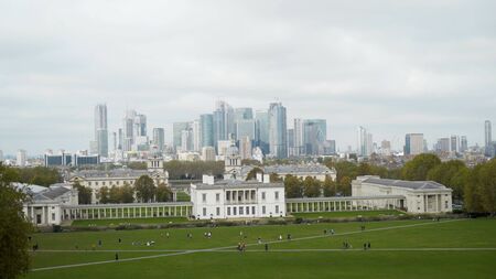 Green glade with old architectural building on background of city. Action. Green glade with old...