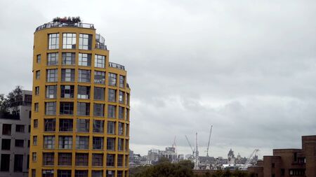 Multi-storey residential building with modern architecture on background of city. Action. Modern...