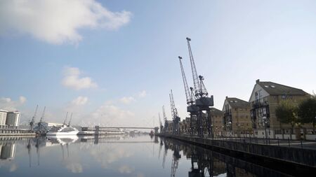 Panorama of port canal with embankment and docks. Action. Beautiful harbour canal with docks on...