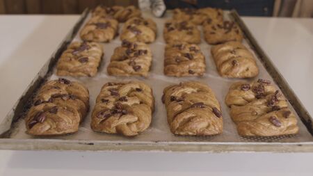 Close up of a baker holding hot tray with freshly baked buns with nuts. Close up of yummy bread...