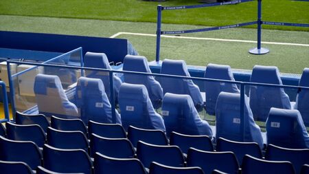 London, Britain-September, 2019: View of empty blue stands in front rows. Action. First seats in stands for VIP persons at football stadium. Comfortable chairs in expensive first places near football fieldのeditorial素材