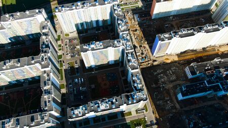 Top view of city street with newly built residential houses, real estate concept. Birds eye top view of white buildings with colorful balconies on a summer day.の写真素材