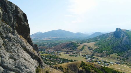 Village among green grass in mountains on a summer day. Shot. Top view of the scenic natural view on a Sunny day.の写真素材