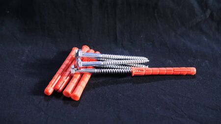 Self-tapping screws with orange dowels. Stock footage. Close-up handful of screws with orange...