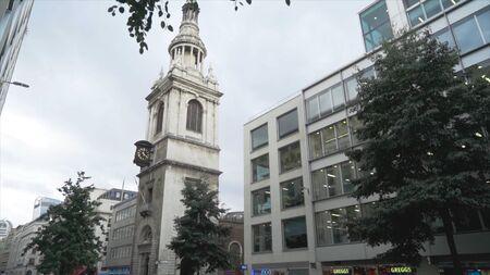 London, Britain-September, 2019: View of old clock tower in center of modern city with walking...