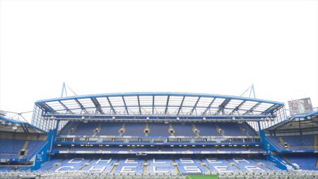 London, Britain-September, 2019: Open empty bleachers of football stadium. Action. Empty stands with name of Chelsea football club and green field with lawn care equipmentのeditorial素材