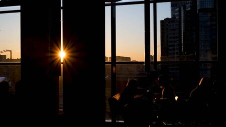 Shadows of people sitting in cafe on background of sunlight. Concept. Beautiful view of silhouettes...