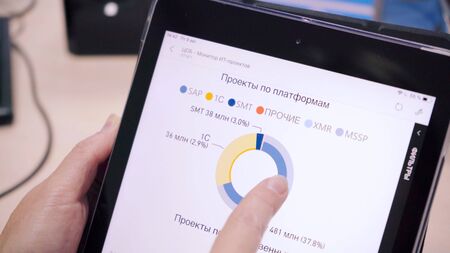 Close-up of man looking at plans in graphs on tablet. Scene. Businessman looks at data for planning...