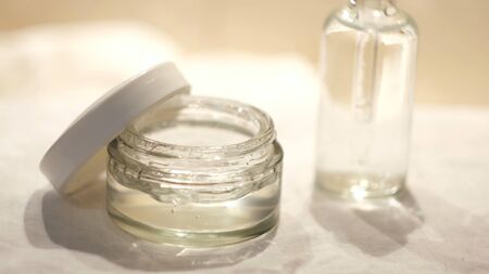 Close-up of woman using facial moisturizer in bathroom. Concept. Care product for moisturizing skin of face. Skin care for face.の写真素材