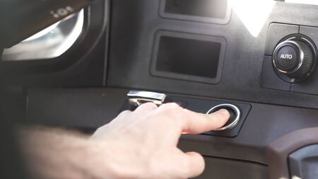 Interior of a modern car, driver starting the engine by pressing the button. Close up of a male hand...