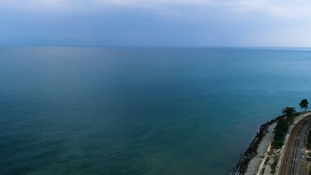 Stunning aerial view of the endless turquoise ocean with the line of horizon that separates water surface and cloudy blue sky. Scene. Beauty of nature, summer travel concept.の写真素材