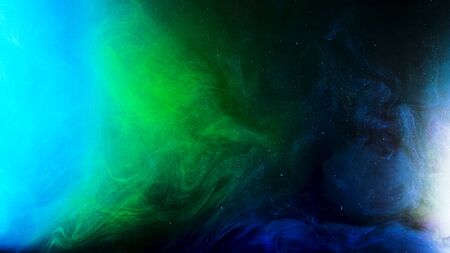 Fantastic view of colorful inks in chaotic motion on black background with glowing particles. Green...