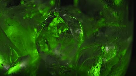 Drink being poured into clear glass with ice. Stock footage. Close-up beautiful ice cubes are...